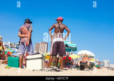RIO DE JANEIRO - MARCH 05, 2013: Brazilian vendors sell drinks and snacks to sunbathers on Ipanema Beach. Stock Photo