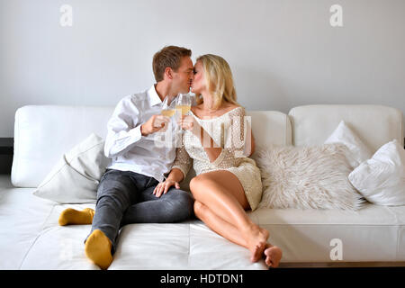 Man, woman, couple on sofa, in love, wine, glass, kiss Stock Photo