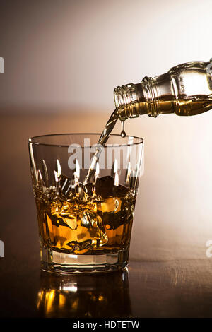 Pouring whiskey into glass close up shoot Stock Photo