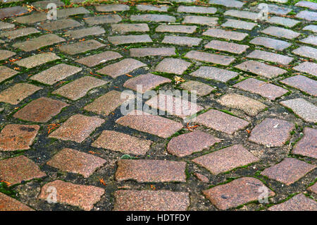 setts, red and grey hewn stones laid on the road Stock Photo