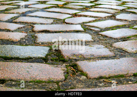 setts, red and grey hewn stones laid on the road Stock Photo