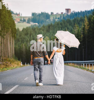 happy loving couple walking along the road in the forest Stock Photo