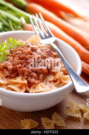 Pasta Bolognese in a bowl with ingredients around Stock Photo