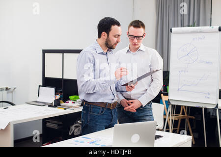 two caucasian corporate executives in casual wear having a business discussion in office. Stock Photo