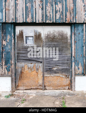 The doors of an abandoned empty deteriorating old derelict building in disrepair in tiny town of Washington, Oklahoma, USA. Stock Photo