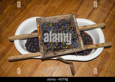 Manual mechanism for crushing grapes. Crush the grapes into juice and wine. Stock Photo