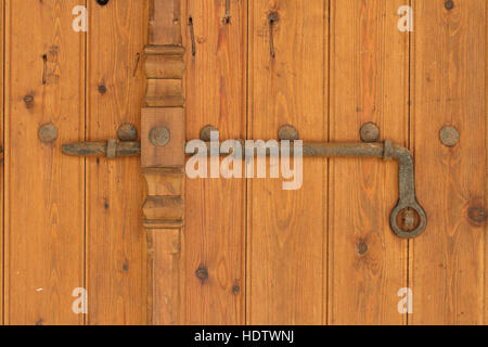 Vintage rusty deadbolt on the old wooden door. Horizontal closeup Stock Photo
