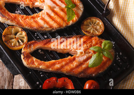 Delicious salmon steak and vegetables on the grill pan closeup. horizontal Stock Photo