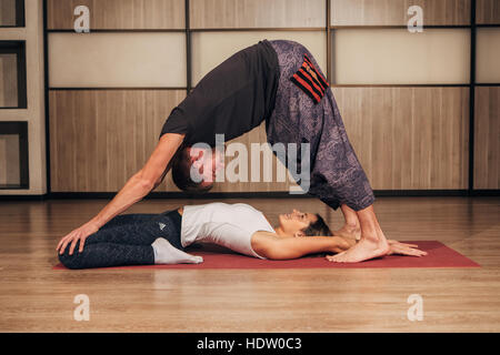 Young man and woman doing yoga in pair Stock Photo