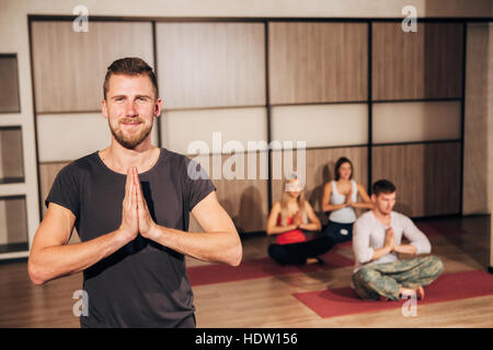 young bearded man practicing yoga and holding hands together Stock Photo