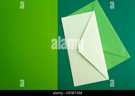 White and green envelope on colourful greenery background. Minimal concept Stock Photo