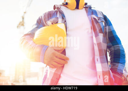 close up of builder holding hardhat on building Stock Photo