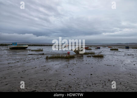 Morcambe bay at low tide late afternoon on a grey day, showing boats on the shore line. Stock Photo