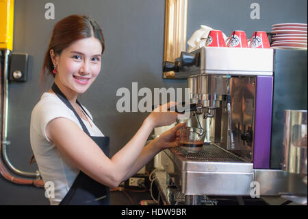 Female bartender makes coffee using coffee machine. Stock Photo