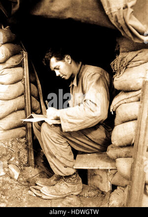 Catching up on his letters to the folks at home during a break Communist forces along the fighting front in Korea, is Pfc. Dwight Exe, 5th Cav. Regt. November 15, 1951. Stock Photo