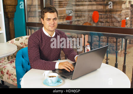 Happy young man smiling and works on his laptop Stock Photo