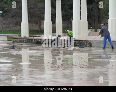 Men carrying out pond maintenance in winter in park in Valencia, Spain Stock Photo