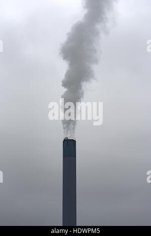 A smoking chimney in dense clouds and fog Stock Photo