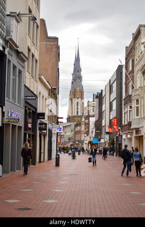 Eindhoven, the Netherlands - 15.09.2015: City center walking area view with The Sacred Heart Church rising above with few people passing buy Stock Photo