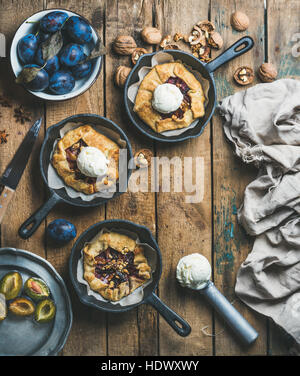Plum and walnut crostata pie with ice-cream scoops in pans Stock Photo