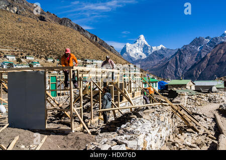 Reconstruction of destroyed houses damaged during the 2015 earthquake with the mountain Ama Dablam (6856m) in the distance. Stock Photo