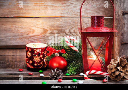 Christmas time red latern with candle light and holiday decorations around, copy space Stock Photo