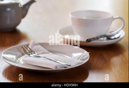 Tea set laid ready for afternoon tea. Table set out with white porcelain tea set. Stock Photo