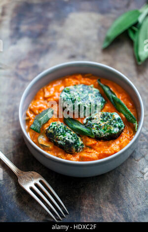 Spinach and ricotta dumplings in tomato and courgette sauce Stock Photo