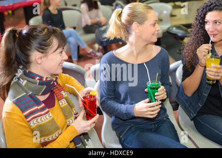 Three seated ladies with drinks Stock Photo