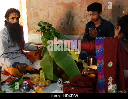 A Hindu priest performing a Puja ceremony inside the Shiva Dol temple in Sivasagar, Assam. Stock Photo