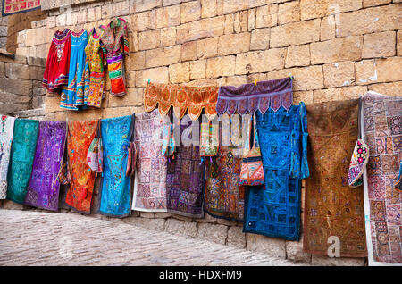 City street market with traditional clothes on the wall of Jaisalmer fort in Rajasthan, India Stock Photo
