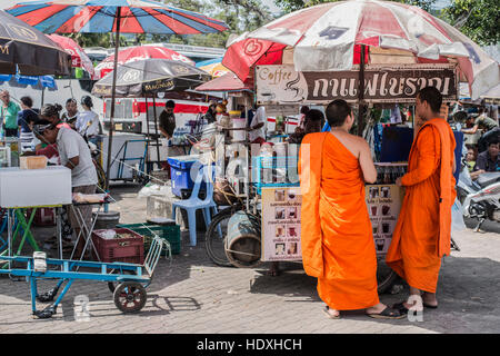 Unidentified monks receive food offering from people on November 24, 2014 in Phuket, Thailand. Offering food is one of most common rituals in Buddhism Stock Photo