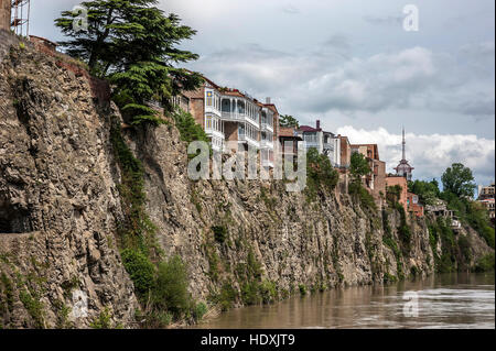 Georgia, Tbilisi. View on Avlabari district , houses on a cliff , leaving the water in the Kura River . Stock Photo