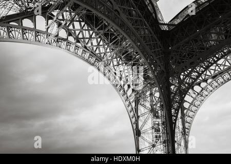 Arch of  the Eiffel tower bearings, the most popular landmark of Paris, France. Monochrome photo with retro style effect Stock Photo