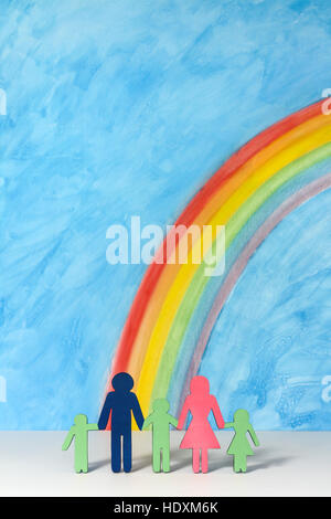 Father, mother and children icons with a rainbow and blue sky; illustrating the concept of traditional family; portrait format. Stock Photo