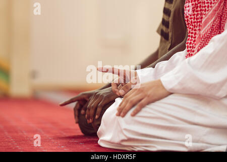Two religious muslim man praying together inside the mosque Stock Photo