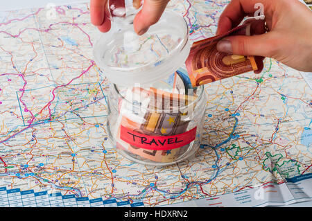 Savings jar for travel on a map Stock Photo