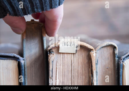Learning english, education concept, tag and vintage books, soft focus. Toned. Stock Photo