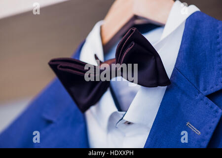Close-up of blue jacket with bow tie on a hanger. Stock Photo