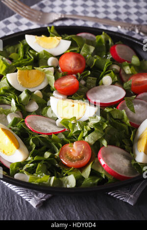 Salad with eggs and spring vegetables close-up on the table. vertical Stock Photo