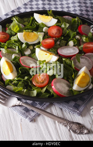 Spring salad with eggs, tomatoes, radishes and sorrel close up on a plate. vertical Stock Photo