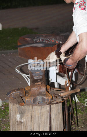 Hands of a blacksmith at work, close-up, vertical Stock Photo