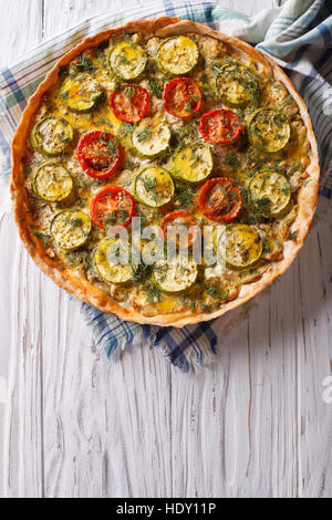 Delicious homemade pie with cheese, tomatoes and zucchini closeup. vertical top view Stock Photo
