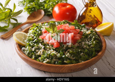 Arabic Salad Tabbouleh close up in a wooden bowl and ingredients. horizontal Stock Photo