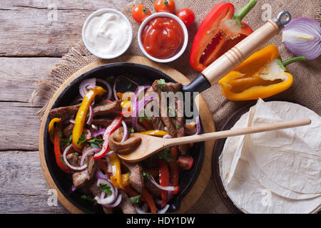 Mexican fajitas on a table in a rustic style. Horizontal close-up view from above Stock Photo