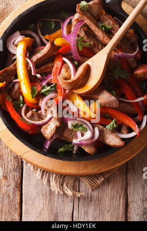 Beef with vegetables in a pan close-up. vertical top view, rustic Stock Photo