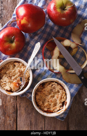 apple crumble in pots for baking on the table. vertical top view of rustic style Stock Photo