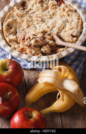 Crumble with apple and banana close-up on the table. vertical, rustic style Stock Photo