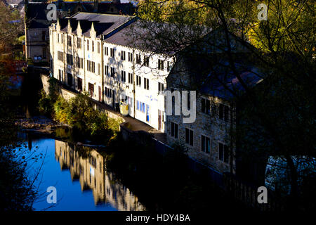 A row of buildings reflected in the calm waters of Hebden Beck, Hebden Bridge, Calderdale, West Yorkshire, UK Stock Photo