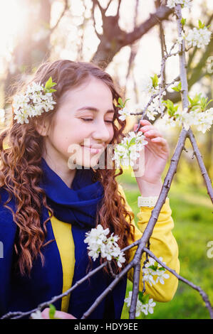 happy young woman near a flowering tree in the Park Stock Photo